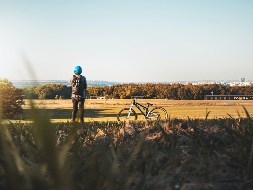 Pyöräilijä pitää taukoa aurinkoisella maaseudulla
