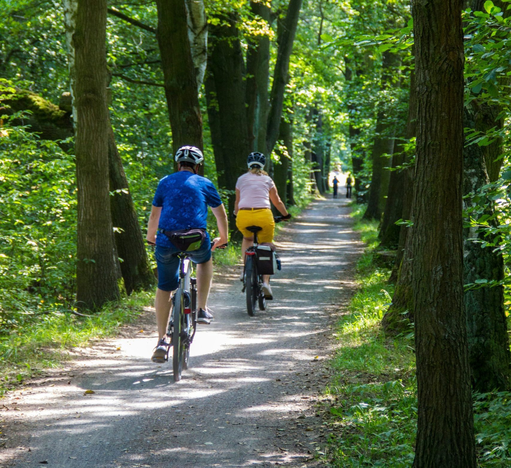 Kaksi pyörälijää hiekkatiellä